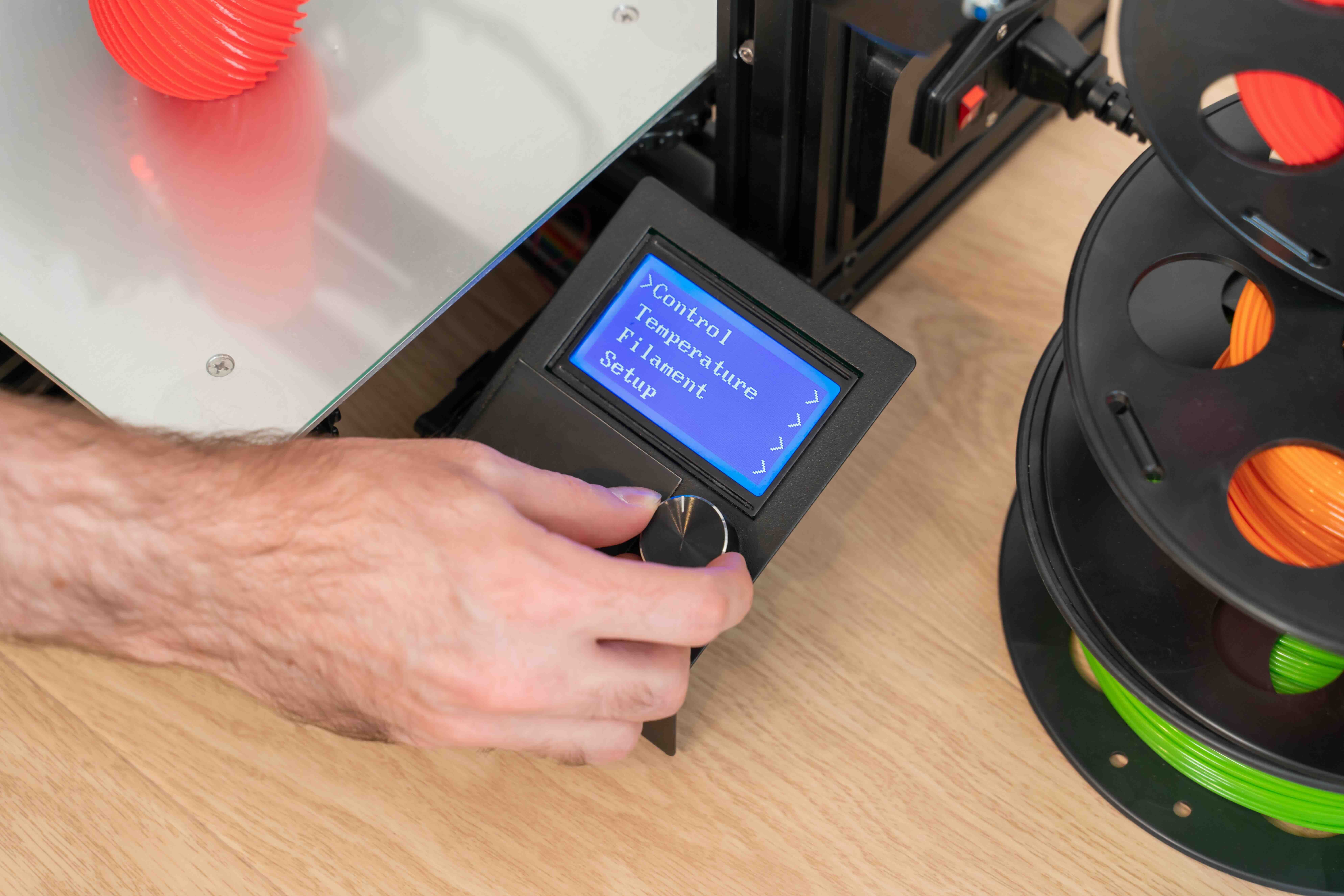 A close-up of a 3D printer filament control digital interface screen, representing how QReserve manages specialized equipment runtimes, monitors consumable tracking, and streamlines workflows for rapid prototyping facilities.