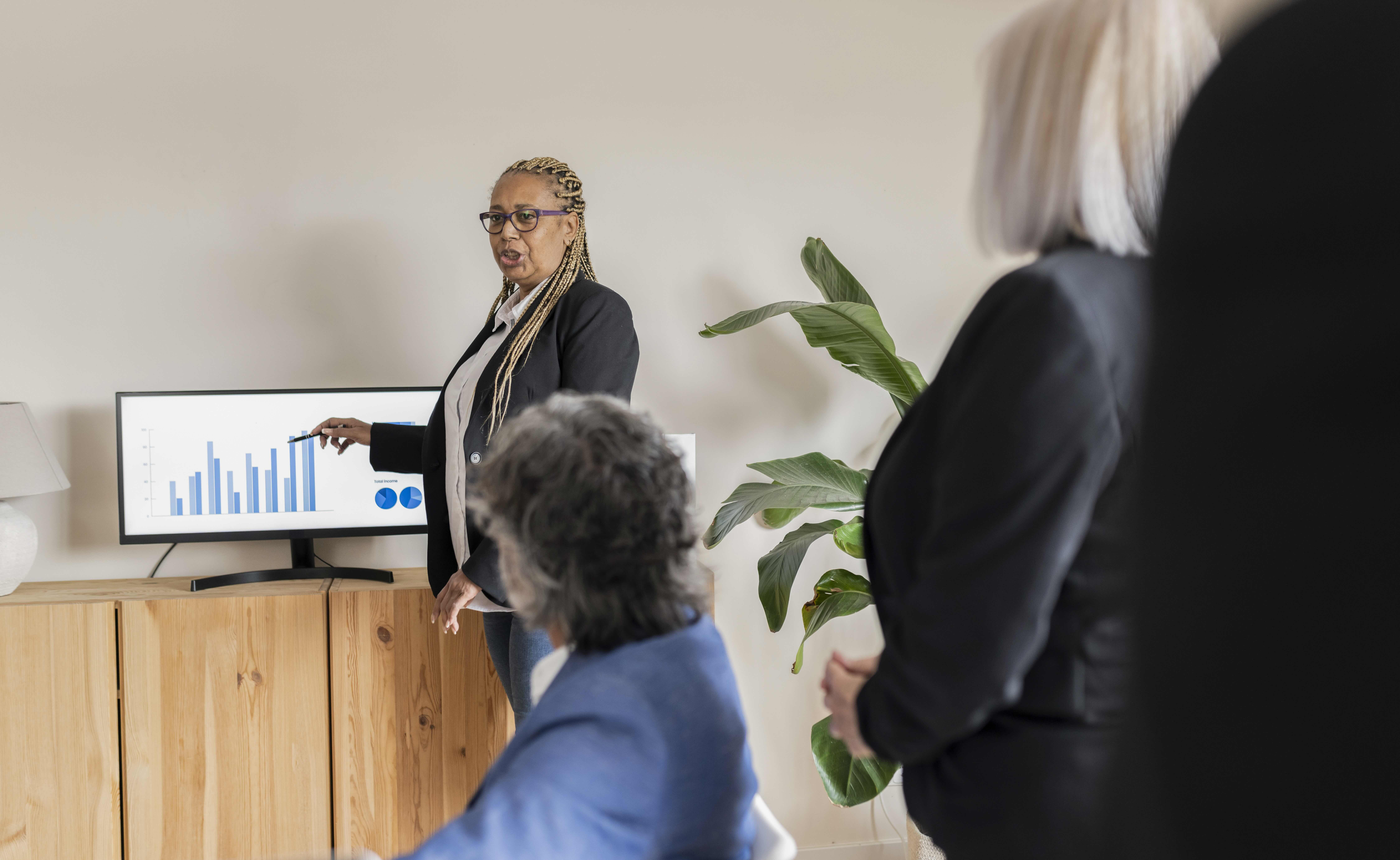 A business presentation displaying data charts on a screen in a modern office, representing how operations leaders use QReserve’s analytics to present utilization metrics and data-driven insights to stakeholders.